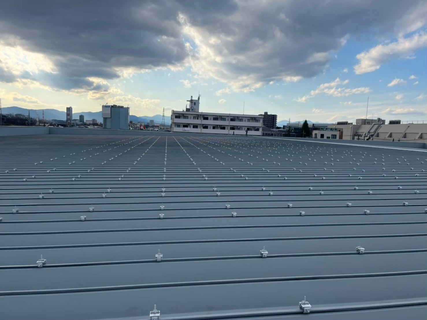 折半屋根上に太陽光パネル固定金具を配置した施工状況