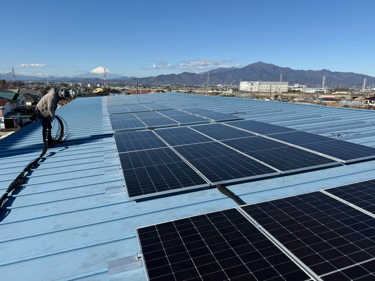 神奈川県平塚市の公共施設体育館屋根における自家消費型太陽光発電設備の施工中全景