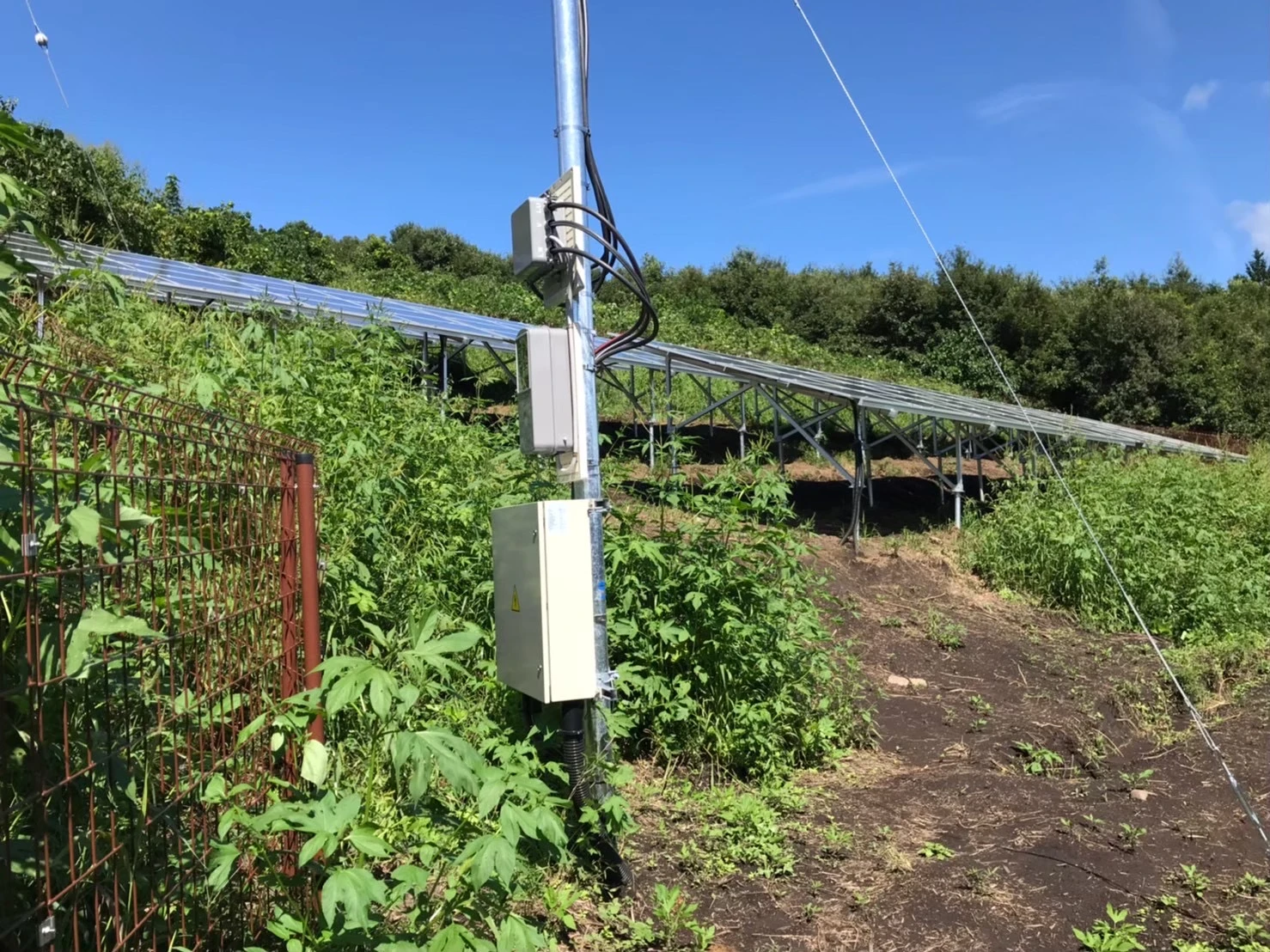 群馬県高山村の野立て太陽光発電所における受電柱と周辺盤の設置状況