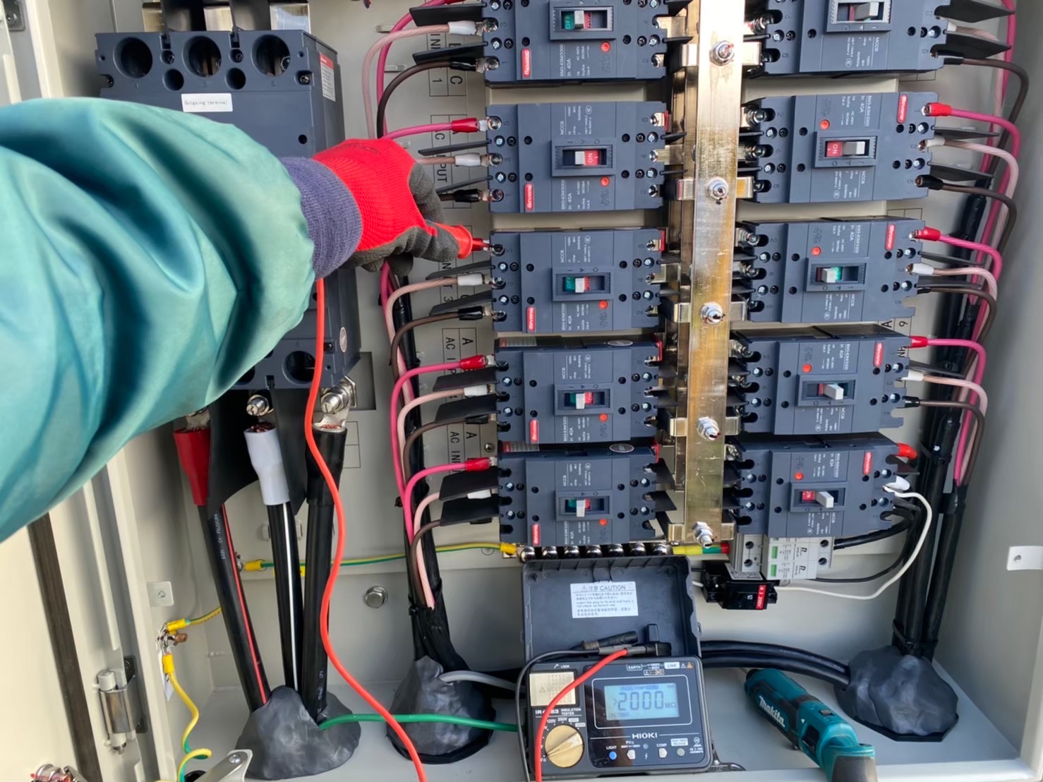 太陽光発電設備の盤内確認と測定作業の写真