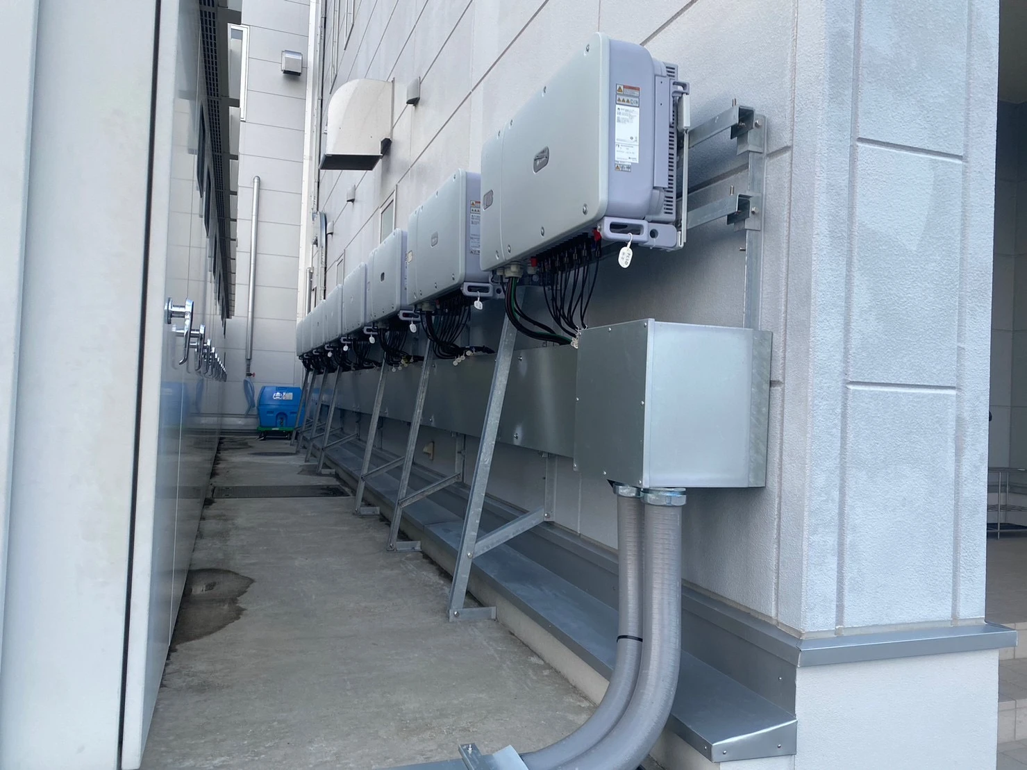 山形県山形市の工場外壁に設置した太陽光発電用PCSと交流側配管