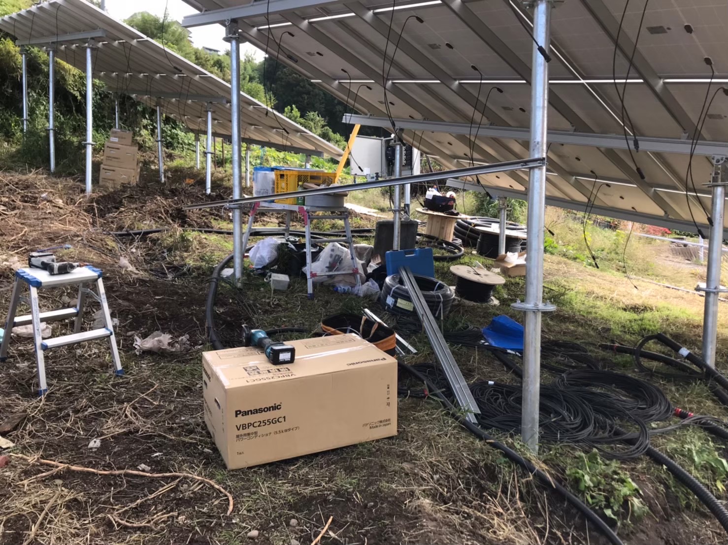 野立て太陽光発電のパネル裏側配線とPCSまわりの施工中写真