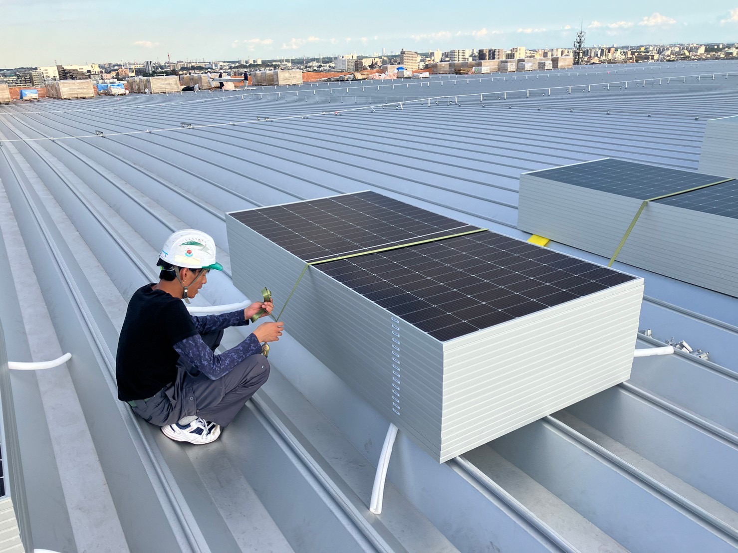 大型物流施設屋根上に仮置きした太陽光パネル束